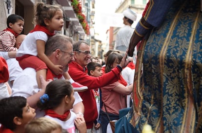 Un hombre toca la mano de un Gigante durante el desfile por Pamplona, el 12 de julio de 2016.