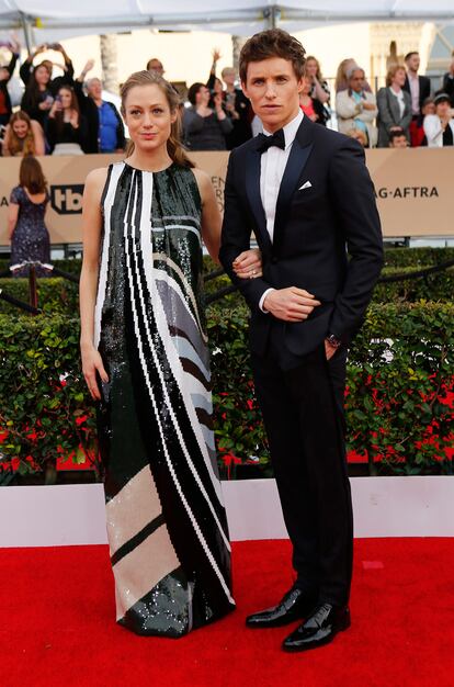 El británico Eddie Redmayne, con esmoquin de Dior,  junto a su mujer Hannah.