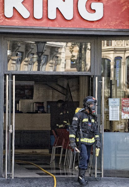 Un bombero sale del restaurante 'fast-food' de Barcelona en el que hoy se ha originado un incendio.