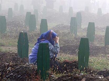 Una musulmana reza ante una tumba en el cementerio de Srebrenica, en septiembre de 2003.