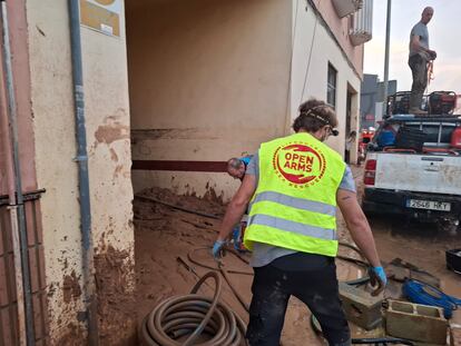 Miembros de la ONG Open Arms trabajan en el desagüe de un garaje.