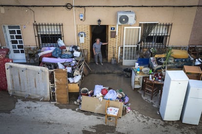 Una mujer se asoma a la calle donde se encuentran sus pertenencias tras las inundaciones en Orihuela en 2019.