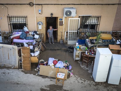 Una mujer se asoma a la calle donde se encuentran sus pertenencias tras las inundaciones en Orihuela en 2019.