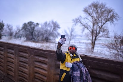 Un migrante se toma una 'selfie' en medio del paisaje nevado, a bordo del tren. 