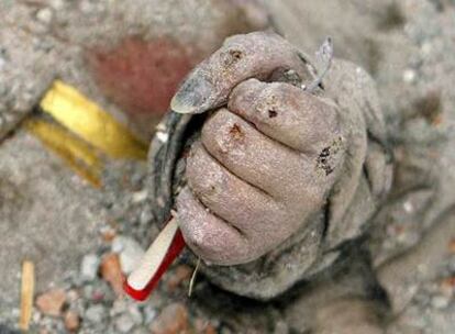 La mano aferrada a un bolígrafo de una víctima del terremoto, entre los escombros de un colegio en la ciudad de Mianzhu.