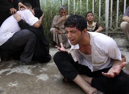 Un grupo de iraquíes llora por sus familiares fallecidos mientras espera frente a una morgue
