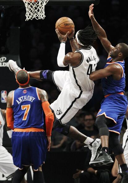 Gerald Wallace, de los Brooklyn Nets, salta ante dos jugadores de los Knicks