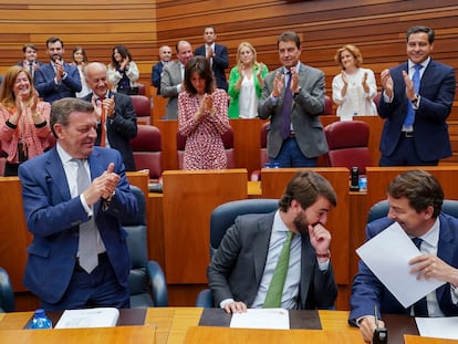 El presidente de la Junta de Castilla y León, Alfonso Fernández Mañueco (a la derecha), ríe mientras conversa con el vicepresidente, Juan García Gallardo (a la izquierda de Mañueco), mientras recibe los aplausos de los miembros de la bancada popular, en las Cortes, en Valladolid, este martes.
