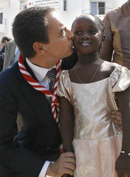 Zapatero besa a una niña senegalesa en la sede de la Cruz Roja en Dakar.