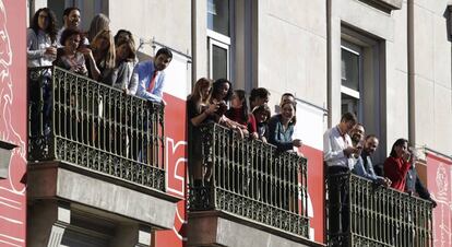 Trabajadores de los edificios adyacentes al Congreso de los Diputados siguen el desfile militar llevado a cabo momentos antes del inicio de la sesión solemne de la apertura de las Cortes en la XII Legislatura.