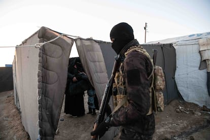 Un efectivo de las Unidades Antiterroristas (YAT, por sus siglas en kurdo) evacúa una tienda del campo de Al Hol antes de proceder al registro de las jaimas en busca de armas y material del ISIS.