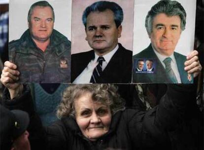 Una mujer serbia muestra las fotos de los tres líderes perseguidos por el Tribunal de La Haya: Mladic (aún en libertad), Milosevic (fallecido en prisión) y Karadzic (recién capturado).