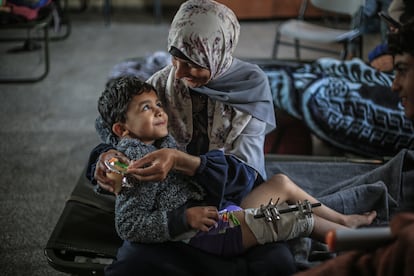Una familiar sujeta en brazos a un niño palestino herido, mientras descansan en una escuela de Jan Yunis, tras haber sido trasladados desde el hospital Indonesio, al norte de la Franja, hacia las zonas del sur. 