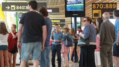 Varios pasajeros esperan en la T4 del aeropuerto de Barajas.