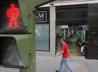 Un viandante pasa por delante de la perfumería asaltada en el distrito de Salamanca.