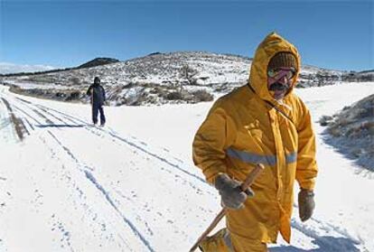 Unos excursionistas caminan por la nieve en el entorno de Sant Joan de Penyagolosa.