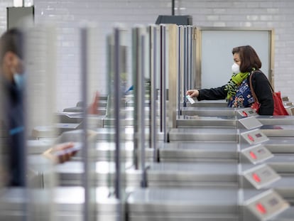 Algunos ciudadanos vuelven al trabajo en transporte público y pasan por la estación de metro Passeig de Gracia en Barcelona.