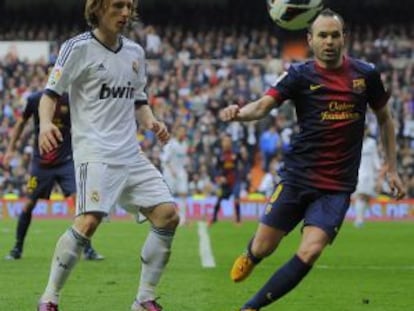 Iniesta y Modric pugnan por el bal&oacute;n.