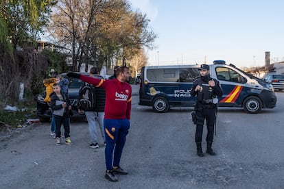 Un grupo de personas frente al cordón policial, tras el tiroteo en el que un hombre se ha atrincherado en su bar de la Cañada Real.