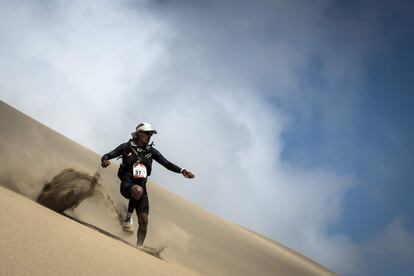 Un participante baja corriendo una duna del desierto de Ica en la cuarta etapa de la carrera, entre Ocucaje y Barlovento, el 1 de diciembre de 2017.