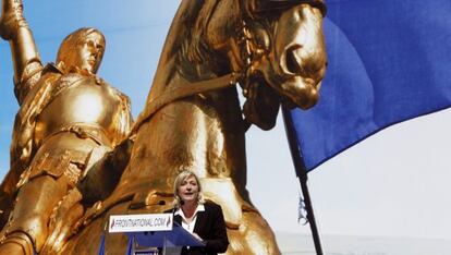 Marine Le Pen, con un p&oacute;ster de Juana de Arco, durante su discurso en la plaza de la &Oacute;pera de Par&iacute;s.