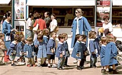 Niños de un colegio recorren, ayer, la Feria del Libro en el paseo de Coches del Retiro madrileño.