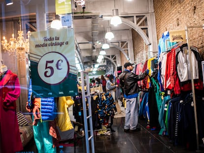 Varios jóvenes buscan ropa de segunda mano en la tienda Humana Vintage de la calle Hortaleza de Madrid.