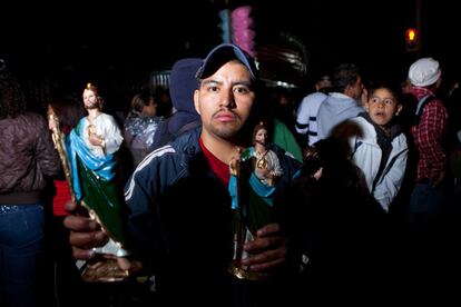 Un joven sostiene dos figuras de San Judas en las inmediaciones de la iglesia de San Hipólito, en el centro de la capital mexicana. Los problemas del progreso urbano fueron el caldo de cultivo de la pasión por San Judas. En los noventa emergió como un santo especializado en los apuros de la creciente clase baja urbana.