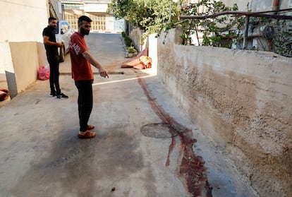 Un palestino señala un rastro de sangre, tras una incursión israelí en Aqabah, Cisjordania.