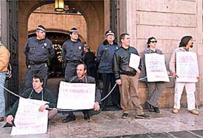 En la imagen, los pocos vecinos que participaron en la protesta contra las maniobras 'especulativas' de la sociedad Procivesa, encadenados en la puerta principal del Ayuntamiento de Barcelona.