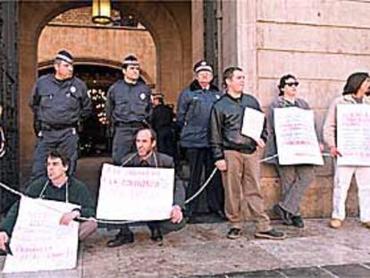 En la imagen, los pocos vecinos que participaron en la protesta contra las maniobras 'especulativas' de la sociedad Procivesa, encadenados en la puerta principal del Ayuntamiento de Barcelona.