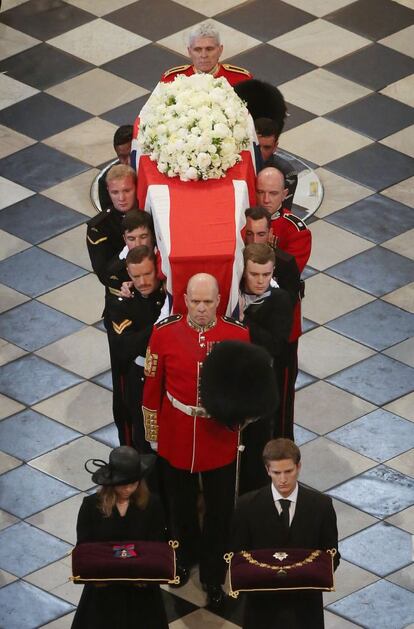 Varios oficiales cargan a hombros el ataúd de la ex primera ministra británica Margaret Thatcher por el pasillo central de la Catedral de San Pablo. Los nietos de la ex mandataria acompañan al féretro, Londres.