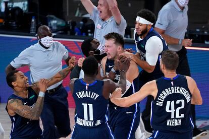Luka Doncic, abrazado por sus compañeros tras el triple que dio el triunfo a Dallas.