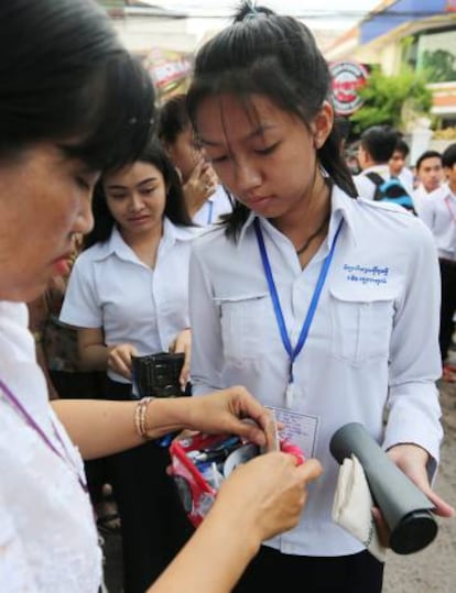 Una agente registra a una estudiante antes del examen del último curso de instituto.