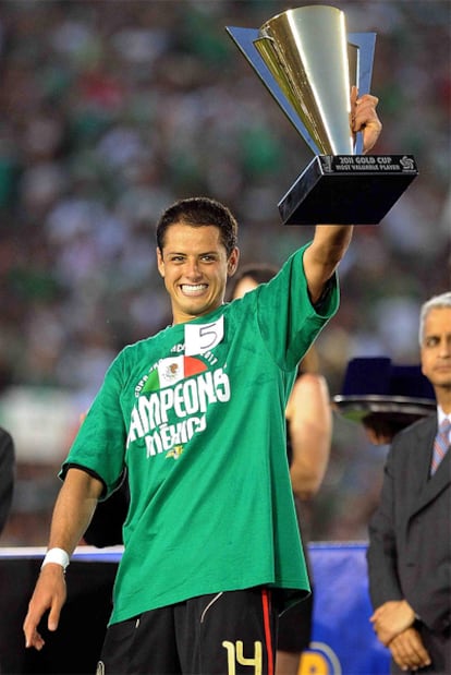 Chicharito alza el trofeo que acredita el triunfo de México.