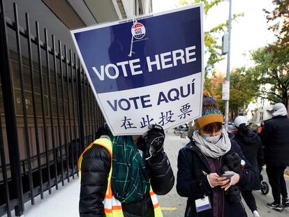 A volunteer with a sign written in English, Spanish and Chinese, in November at local elections in New York.