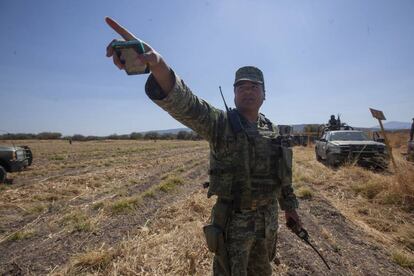 El teniente Armenta, en el campo que custodia en Guanajuato. Atrás, de amarillo, los indicadores del ducto de Pemex.