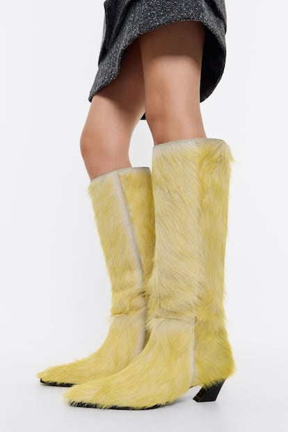 Próximamente encontraremos en Bimba y Lola la versión peluda de la bota de estilo cowboy. Unas botas con la característica silueta de las botas de inspiración western, un tacón más fino inclinado y forradas con pelo amarillo. (390 euros).