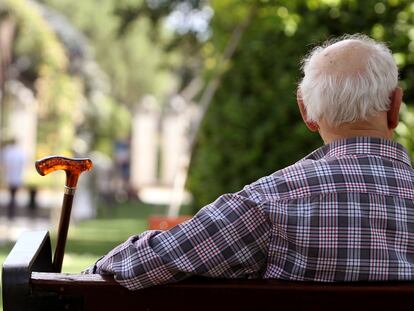 Un pensionista sentado en un banco en un parque de Madrid.