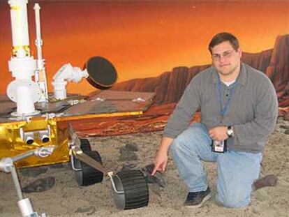 Chris Voorhees, ingeniero de robótica, posa en JPL junto a una maqueta de los robots marcianos.
