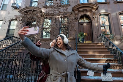 Una pareja de turistas se toma fotos, el 14 de enero de 2025, frente a la casa de Carrie Bradshaw en 'Sexo en Nueva York'. 
