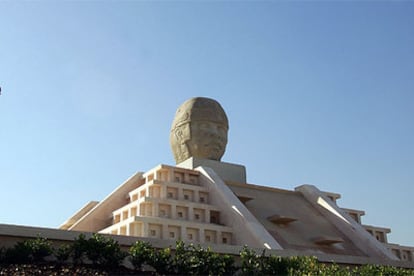 Un ciudadano observa la réplica colocada en Vallecas de la cabeza olmeca mexicana apodada <i>El Rey</i>.