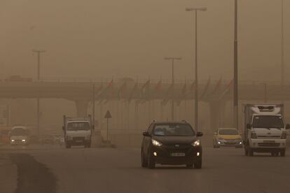 Los coches circulan por la ciudad jordana de Amman bajo una espesa bruma causada por la tormenta de arena que afecta a la zona.