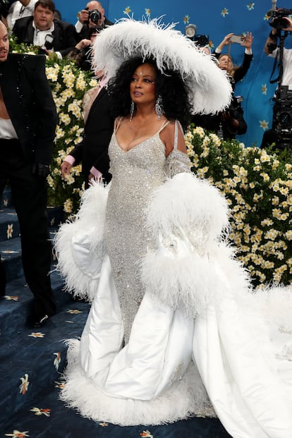 81 yaşındaki şarkıcı ve oyuncu Diana Ross, şapkalı beyaz kıyafeti ve uzun kuyruğuyla dikkat çeken tüylü paltosuyla göz kamaştırdı. Nijeryalı tasarımcı Ugo Mozie'nin imzasını taşıyan tasarımda, pelerinin üzerine Mozie'nin çocuklarının ve torunlarının isimleri işleniyor.