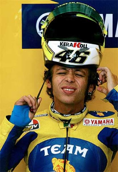 Valentino Rossi se coloca el casco con gesto dolorido por las lesiones que sufre en su mano izquierda.