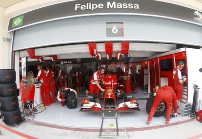 Mecanicos trabajan en el coche de Felipe Massa.
