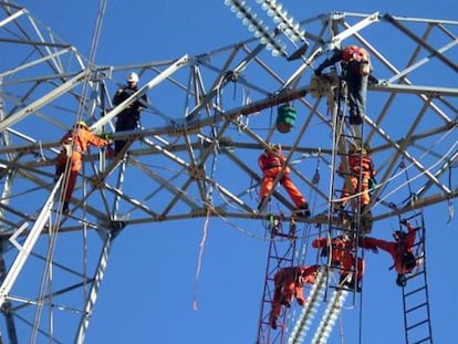 Empleados de Abengoa en una l&iacute;nea de transmisi&oacute;n el&eacute;ctrica.