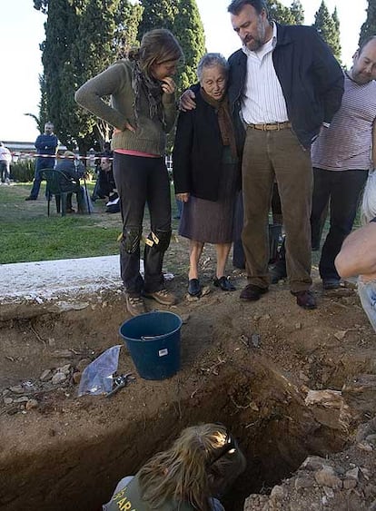 Antonia Trigo (centro) ante la fosa de su padre en Calañas, Huelva.