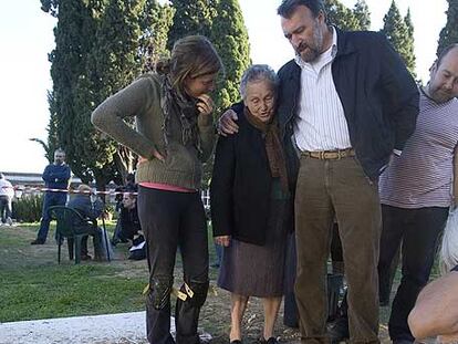 Antonia Trigo (centro) ante la fosa de su padre en Calañas, Huelva.