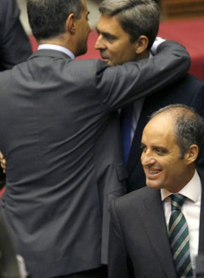 Ricardo Costa (de espaldas) y Vicente Rambla se abrazan, en presencia de Camps, antes del pleno.